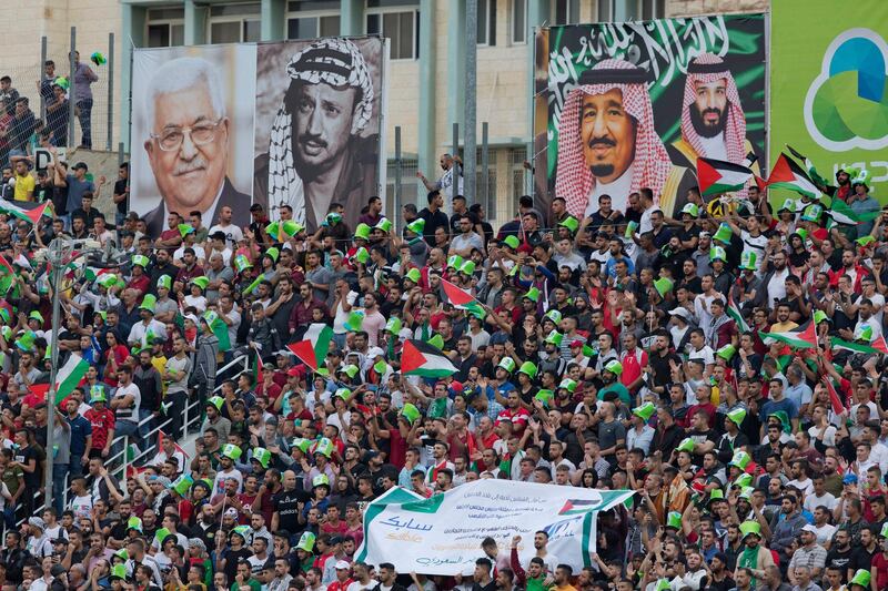 Pictures, from left, of Palestinian President Mahmoud Abbas, the late Palestinian leader Yasser Arafat, Saudi Arabia's King Salman and Crown Prince Mohammad bin Salman, adorn the stadium as fans cheer for their teams. The match ended with a 0-0 draw. AP Photo