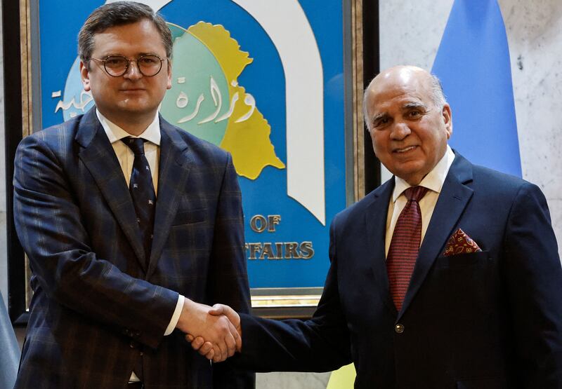 Ukrainian Foreign Minister Dmytro Kuleba shakes hands with Iraqi counterpart Fuad Hussein in Baghdad on Monday. Reuters