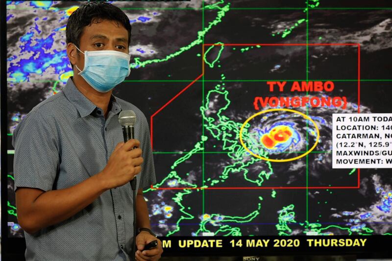 Weather forecaster Christopher Perez points to a projected track of Typhoon Vongfong.  EPA