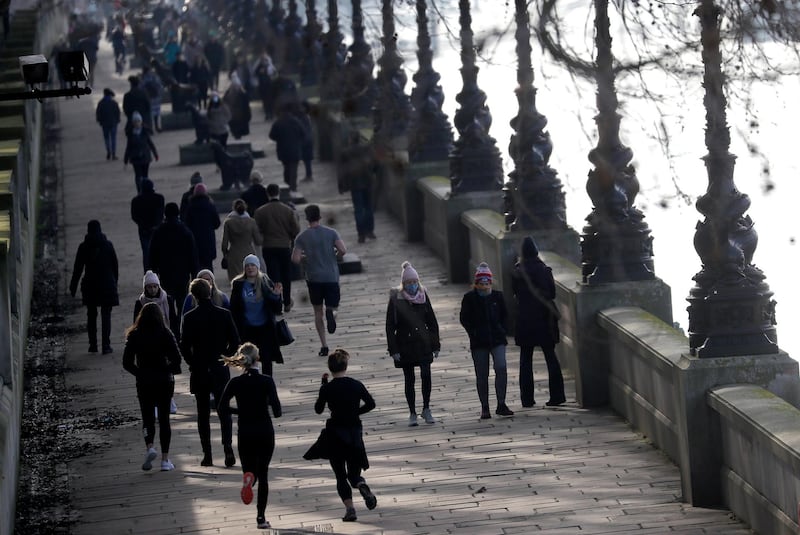 People exercise along the bank of the River Thames in London. AP Photo
