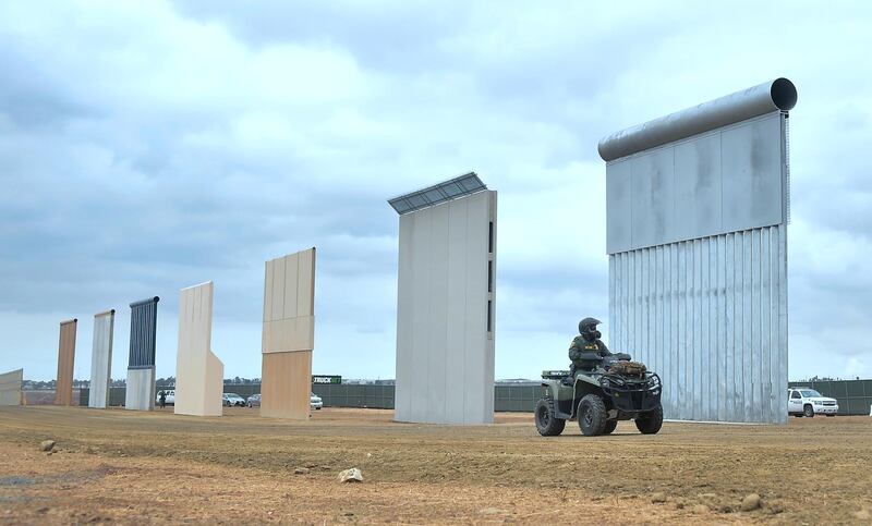 (FILES) In this file photo taken on November 1, 2017 a Homeland Security border patrol officer rides an All Terrain Vehicle (ATV) past prototypes of US President Donald Trump's proposed border wall in San Diego, California.   The Pentagon notified the US Congress on March 25, 2019 that it has authorised $1 billion for new border wall construction at the US-Mexico border. / AFP / FREDERIC J. BROWN
