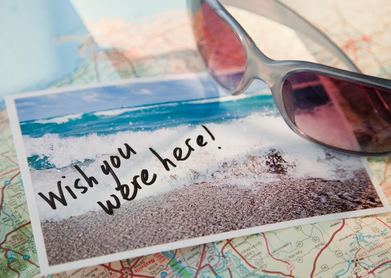 Close-up of sunglasses and postcard on map. Getty Images