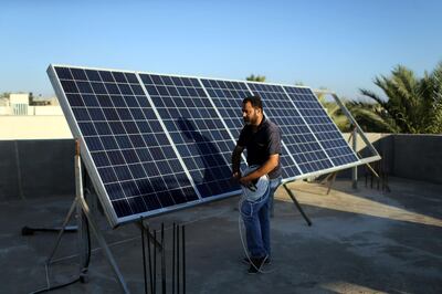 A Palestinian man installs solar panels on a house rooftop in Khan Younis in the southern Gaza Strip July 30, 2018. Picture taken July 30, 2018. REUTERS/Ibraheem Abu Mustafa