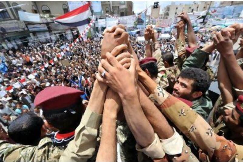 Yemeni soldiers hold their hands as they join anti-government protesters demanding the departure of President Ali Abdullah Saleh, in Sana'a yesterday. Yahya Arhab / EPA