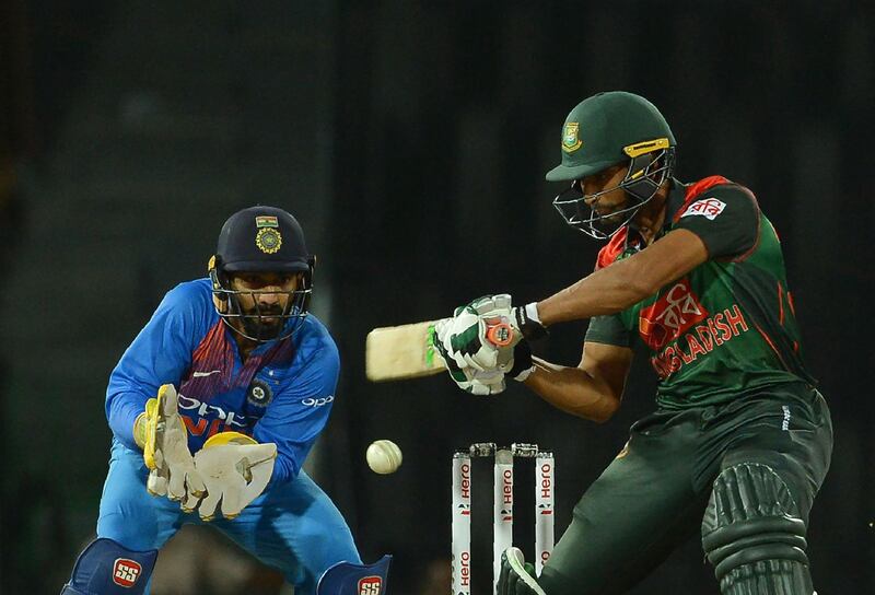 Bangladesh cricket captain Mahmudullah (R) is watched by Indian wicketkeeper Dinesh Karthik as he plays a shot during the fifth Twenty20 (T20) international cricket match between India and Bangladesh of the tri-nation Nidahas Trophy at the R. Premadasa stadium in Colombo on March 14, 2018. / AFP PHOTO / LAKRUWAN WANNIARACHCHI