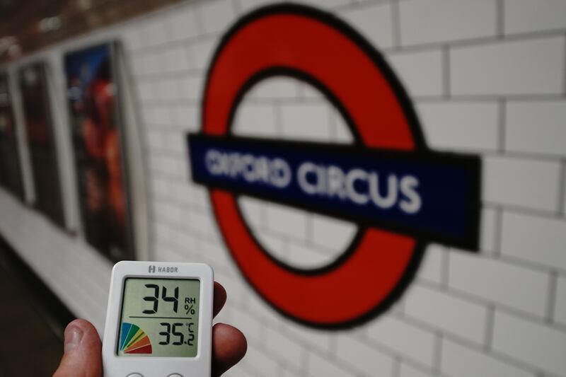 A person holds a thermometer at Oxford Road station of the London underground in 2022. PA