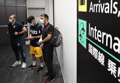 Three members of the Olympic refugee team, Ahmad Alikaj (L), Abdullah Sediqi (C) and coach Alireza Nassrazadany (R) arrive at the Narita international airport in Narita, Chiba prefecture on July 14, 2021.  (Photo by Kazuhiro NOGI  /  AFP)