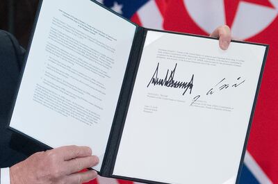 US President Donald Trump holds up a document signed by him and North Korea's leader Kim Jong Un following a signing ceremony during their historic US-North Korea summit, at the Capella Hotel on Sentosa island in Singapore on June 12, 2018.
 Donald Trump and Kim Jong Un became on June 12 the first sitting US and North Korean leaders to meet, shake hands and negotiate to end a decades-old nuclear stand-off. / AFP / SAUL LOEB

