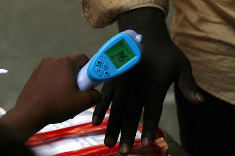 An official checks the temperature of a voter as part of precautions against the coronavirus as he arrives to cast his vote in the Tamil Nadu state assembly elections in Chennai, India. AP Photo
