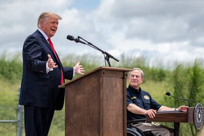 Texas Governor Greg Abbott listens as former US president Donald Trump speaks during a visit to the border wall near Pharr, Texas on June 30, 2021. AFP