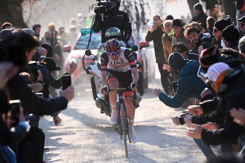 Tadej Pogacar pedals during the Strade Bianche as race fans cheer him on. AP