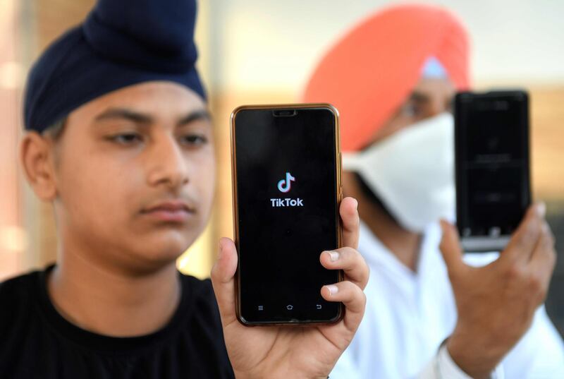 (FILES) In this file photo taken on June 30, 2020, Indian mobile users browse through the Chinese owned video-sharing 'Tik Tok' app on smartphones in Amritsar. When India banned TikTok in June 2020, it closed a window to the wider world for legions of women outside the big cities that provided fun, fame and even fortune. - TO GO WITH India-China-TikTok-science-software-lifestyle,FOCUS by Aishwarya KUMAR
 / AFP / NARINDER NANU / TO GO WITH India-China-TikTok-science-software-lifestyle,FOCUS by Aishwarya KUMAR

