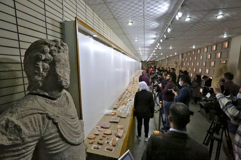 Iraqis look at antiquities on display in Baghdad in February 2022 after they were returned by a private museum in Lebanon. AFP