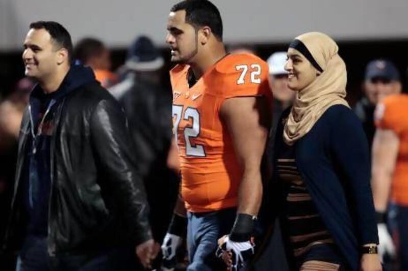 Former University of Virginia offensive tackle Oday Aboushi, centre, walks with his Palestinian parents during the Cavaliers’ final home game last season. Aboushi was drafted by the New York Jets in the fifth round and said he is proud to be one of a handful of Arab players in the NFL. Steve Helber / AP Photo