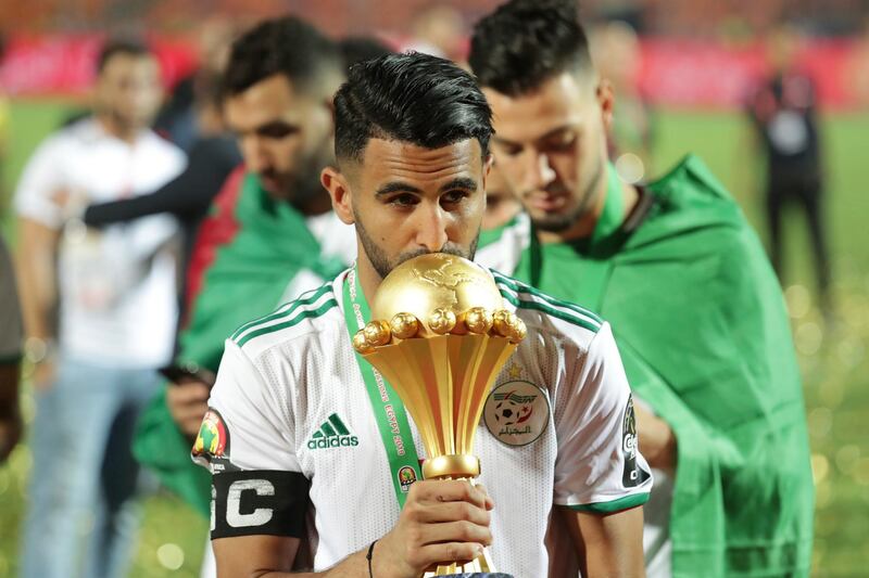 Algeria's Riyad Mahrez kisses the trophy after winning the African Cup of Nations final soccer match between Algeria and Senegal in Cairo International stadium in Cairo, Egypt, Saturday, July 20, 2019. (AP Photo/Hassan Ammar)
