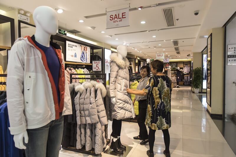 A customer looks at a down jacket displayed inside the Bosideng International Holdings Ltd. flagship clothing store in Shanghai, China, on Friday, July 14, 2017. Bosideng, a Chinese transliteration of "Boston," produces the nation's top-selling line of��down-filled puffer coats. Photographer: Qilai Shen/Bloomberg