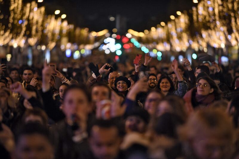 People cheer as the lights come on. AFP
