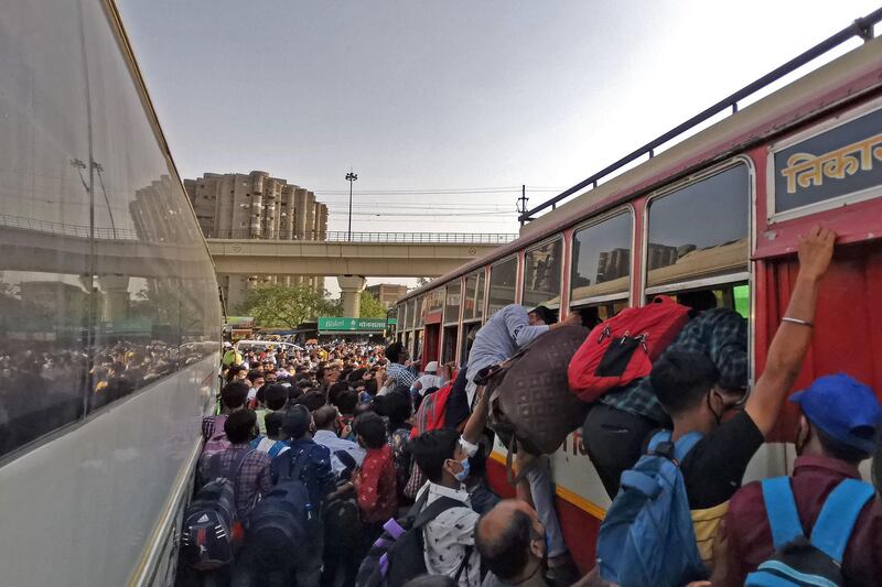 People crowd at a bus station before a week-long lockdown ordered by the Delhi government comes into effect. AFP