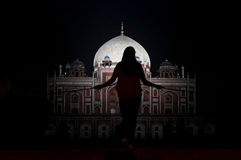 A visitor stands at a fence in front of Humayun's Tomb, a 16th-century Mughal monument in New Delhi, India. AFP