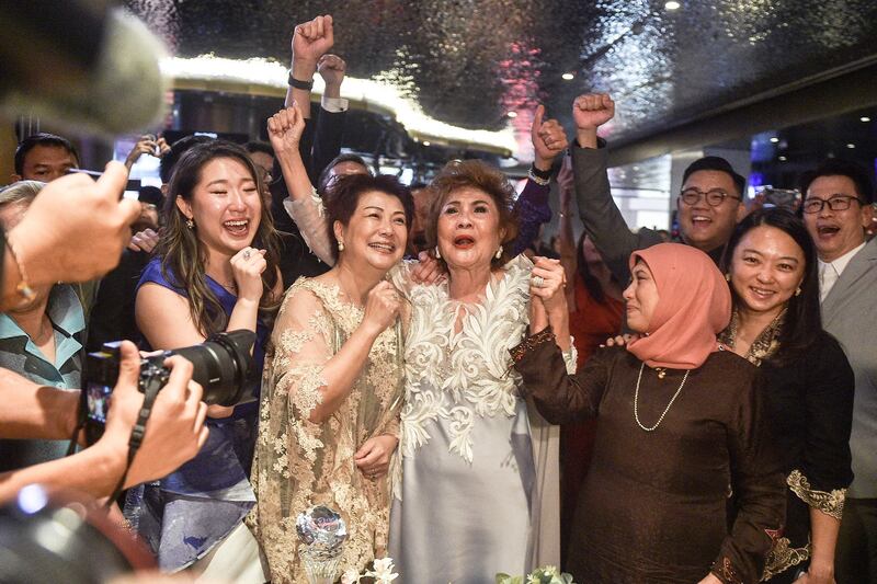 Janet Yeoh (centre R), mother of actress Michelle Yeoh, celebrates after her daughter won the award for Best Actress in a Leading Role at the 95th Academy Awards in Los Angeles, at an event in Kuala Lumpur on March 13, 2023.  (Photo by Arif Kartono  /  AFP)