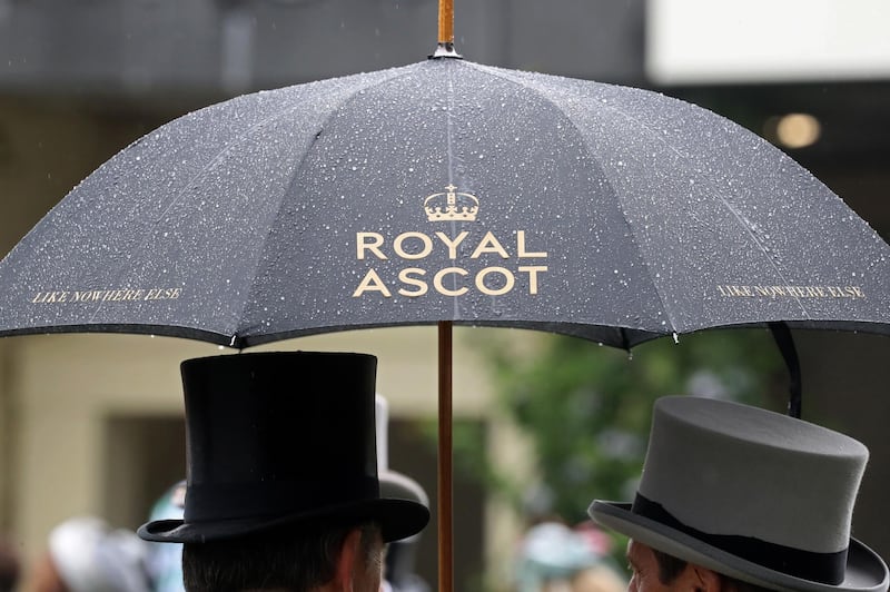 Racegoers talk under an umbrella on day two of Royal Ascot at Ascot Racecourse in Ascot, England. Getty Images