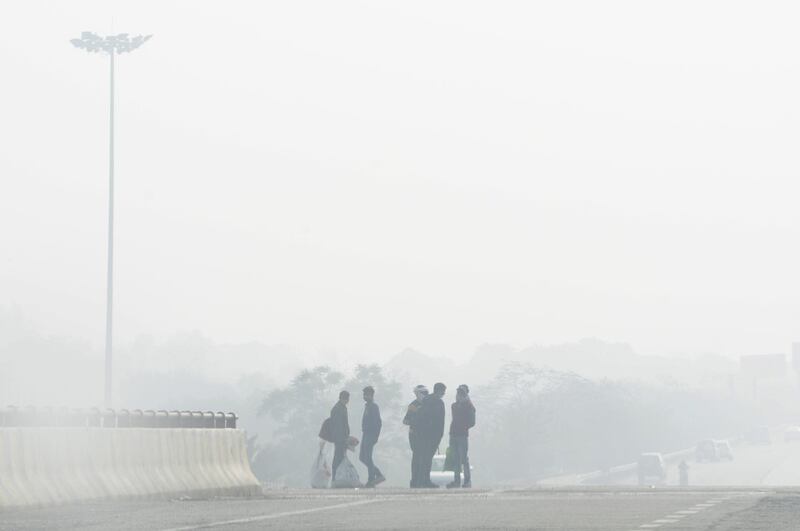 GREATER NOIDA, INDIA  DECEMBER 15: People on Noida Expressway amid heavy haze, on December 15, 2020 in Greater Noida, India. The residents of national capital continued to shiver as icy cold winds blowing from snow-laden western Himalayas have led to a dip in the mercury on Tuesday. The city recorded the lowest minimum temperature of the season so far at 4.1 degrees Celsius, which is four notches below the normal. (Photo by Sunil Ghosh/Hindustan Times via Getty Images)