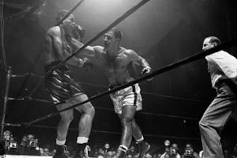Joe Louis winces from a right to the head from Rocky Marciano, right, during the fifth round of their non-title bout at Madison Square Garden, New York, in October 1951. Marciano won by a technical knockout in round eight.