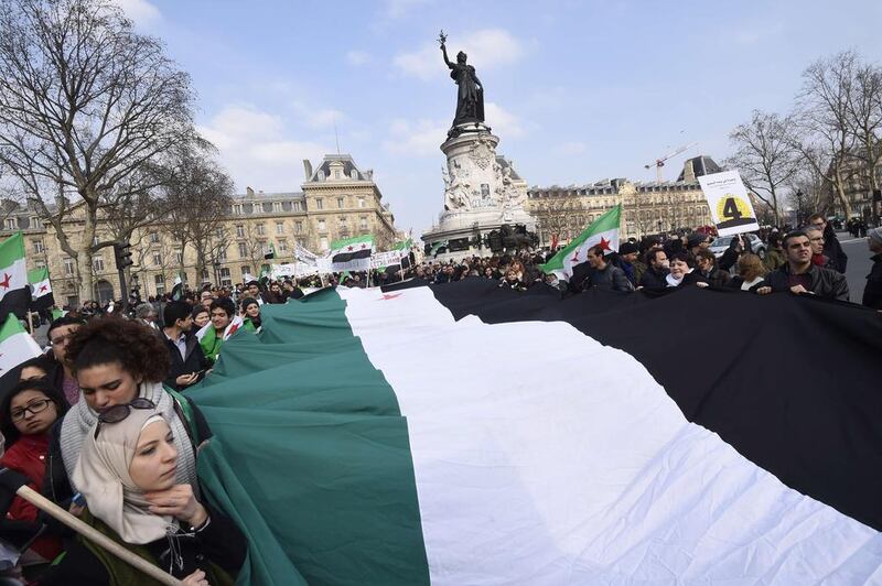 Demonstrators hold a large Syrian independence flag as they mark the fourth anniversary of the start of the Syrian conflict on March 14 in Paris. AFP Photo