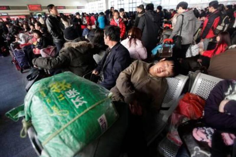 A passenger sleeps as he waits for his train at a waiting hall of the Beijing West Railway Station, January 26, 2011. January 19  marked the beginning of the annual Spring Festival travel rush, with an expected 2.56 billion passenger trips in the coming 40 days. REUTERS/Jason Lee (CHINA - Tags: TRANSPORT) *** Local Caption ***  PEK302_CHINA-_0126_11.JPG