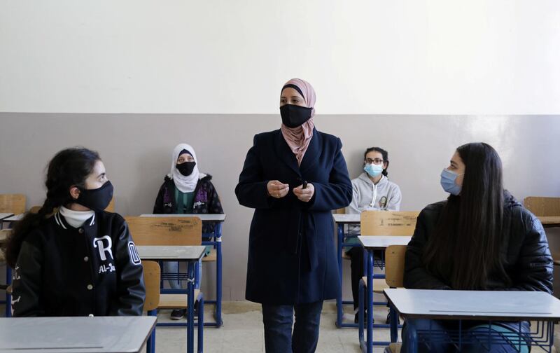 Students listen to their teacher during a lesson following the reopening of their school in Amman. Reuters