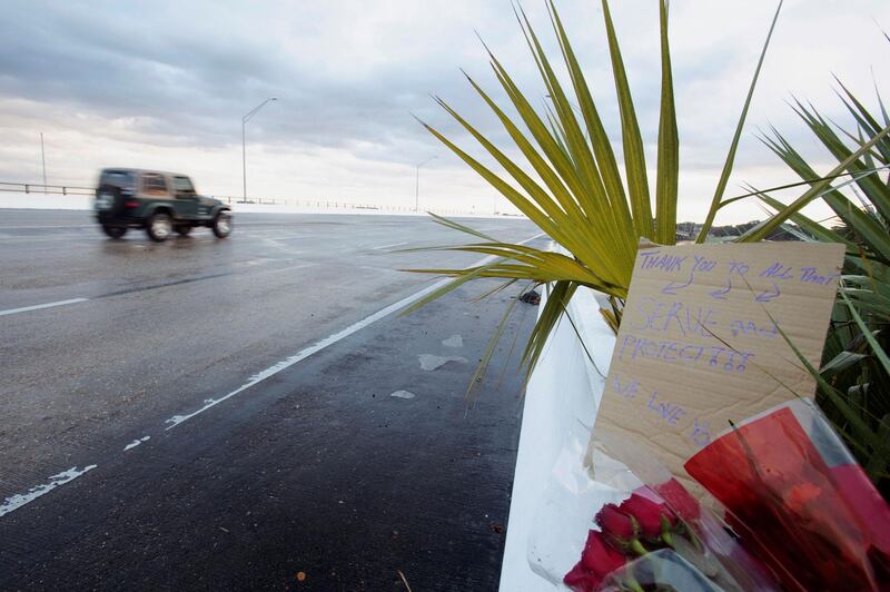 Flowers and a message are left on the entrance bridge after a member of the Saudi Air Force visiting the United States for military training was the suspect in a shooting at Naval Air Station Pensacola, in Pensacola, Florida, U.S. December 6, 2019.  REUTERS/Michael Spooneybarger