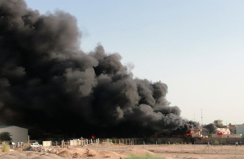 Smoke rises from a fire that broke out at Baghdad's largest ballot box storage site, where ballots from Iraq's May parliamentary elections are stored, in Baghdad, Iraq, on Sunday, June 10, 2018. Hadi Mizban / AP Photo