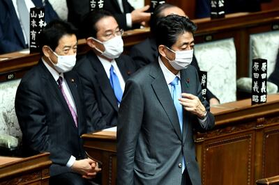 Shinzo Abe, right, walks past Prime Minister Fumio Kishida, centre, during a parliament session in Tokyo earlier in the month. AFP