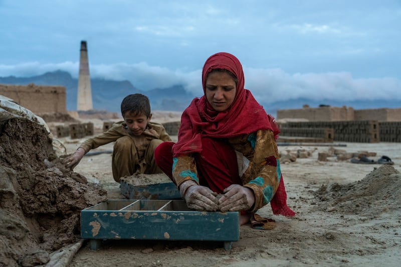 They haul cannisters of water and carry the wooden brick moulds filled with mud to put in the sun to dry.