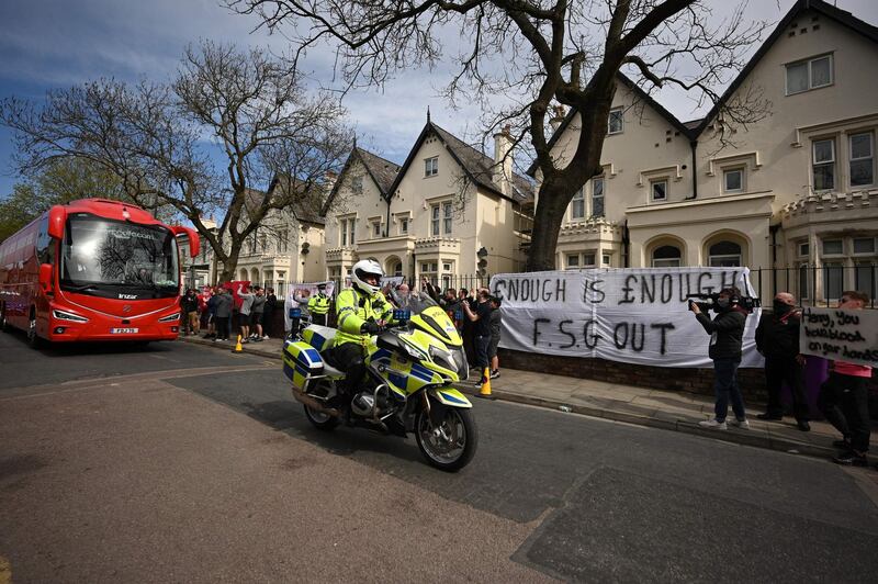 Supporters protest against Liverpool's US owner John Henry and the Fenway Sports Group as the team bus arrives at Anfield ahead of their game against Newcastle. AFP