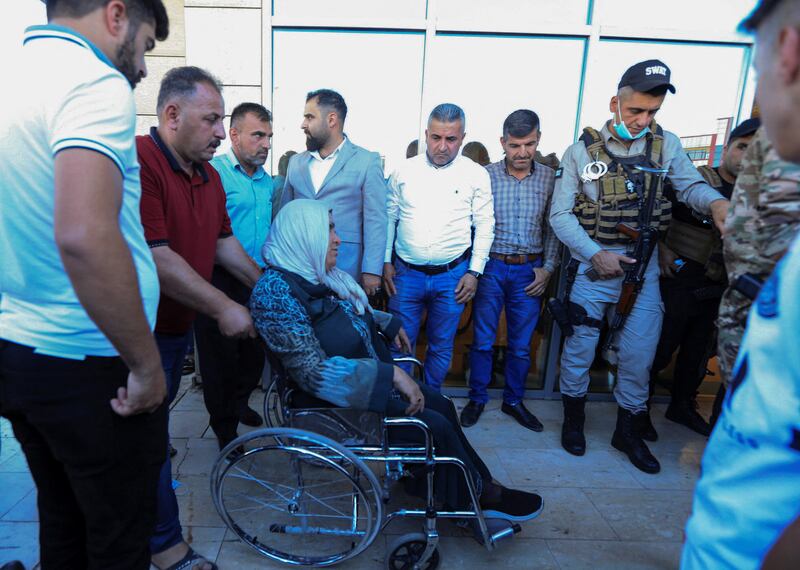 A man pushes a wheelchair carrying a woman after the attack. Reuters