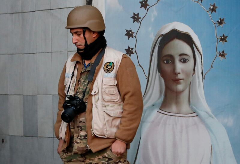A soldier stands next of a portrait of the Virgin Mary where the protesters block a major highway in Nahr El Kalb, Lebanon. AP Photo