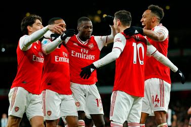 Arsenal's German midfielder Mesut Ozil (2nd R) celebrates with teammates after scoring their third goal during the English Premier League football match between Arsenal and Newcastle United at the Emirates Stadium in London on February 16, 2020. - RESTRICTED TO EDITORIAL USE. No use with unauthorized audio, video, data, fixture lists, club/league logos or 'live' services. Online in-match use limited to 120 images. An additional 40 images may be used in extra time. No video emulation. Social media in-match use limited to 120 images. An additional 40 images may be used in extra time. No use in betting publications, games or single club/league/player publications. / AFP / Ian KINGTON / RESTRICTED TO EDITORIAL USE. No use with unauthorized audio, video, data, fixture lists, club/league logos or 'live' services. Online in-match use limited to 120 images. An additional 40 images may be used in extra time. No video emulation. Social media in-match use limited to 120 images. An additional 40 images may be used in extra time. No use in betting publications, games or single club/league/player publications.