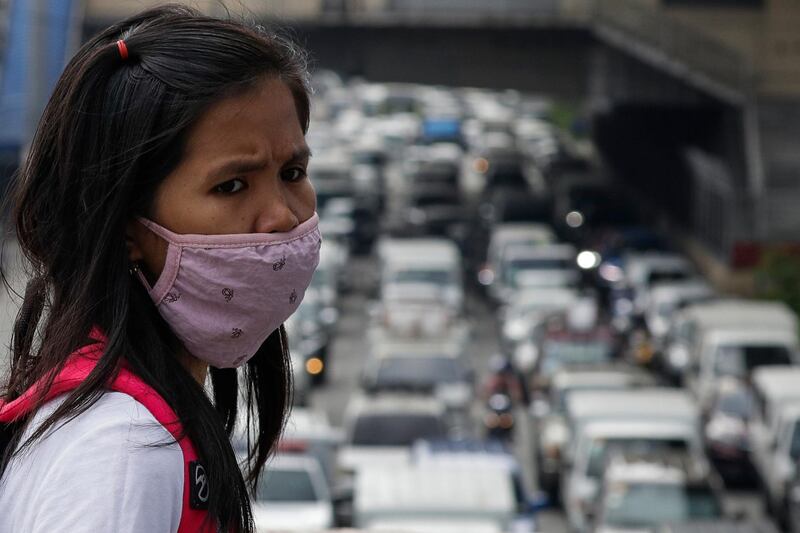 A woman wearing a protective mask looks as traffic builds up during the first day of the easing of lockdown measures in Manila. AP Photo