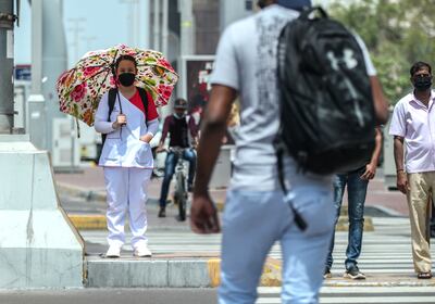 Pedestrians on Hamdan Street in central Abu Dhabi on a hot and gusty day. Victor Besa / The National