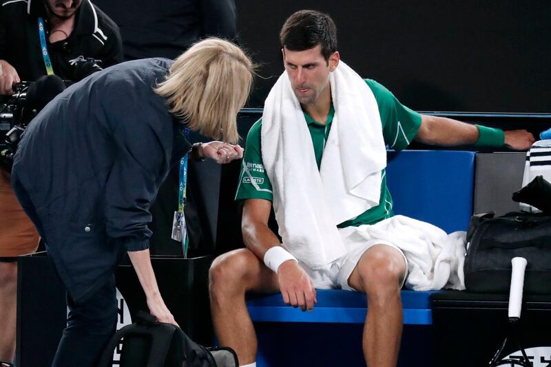 Novak Djokovic talks to a trainer. AP