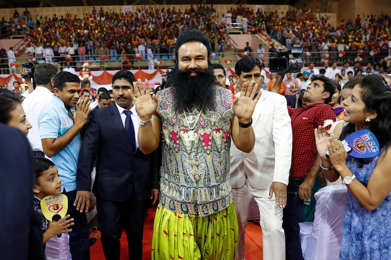 FILE - In this Oct. 5, 2016 file photo, Indian spiritual guru who calls himself Saint Dr. Gurmeet Ram Rahim Singh Ji Insan, center, greets followers as he arrives for a press conference ahead of the release of his new movie "MSG, The Warrior Lion Heart," in New Delhi, India. A judge on Monday, AUg.28, 2017 sentenced the flamboyant and controversial Indian spiritual guru to 10 years in prison on charges of raping two female followers. (AP Photo/Tsering Topgyal, File)