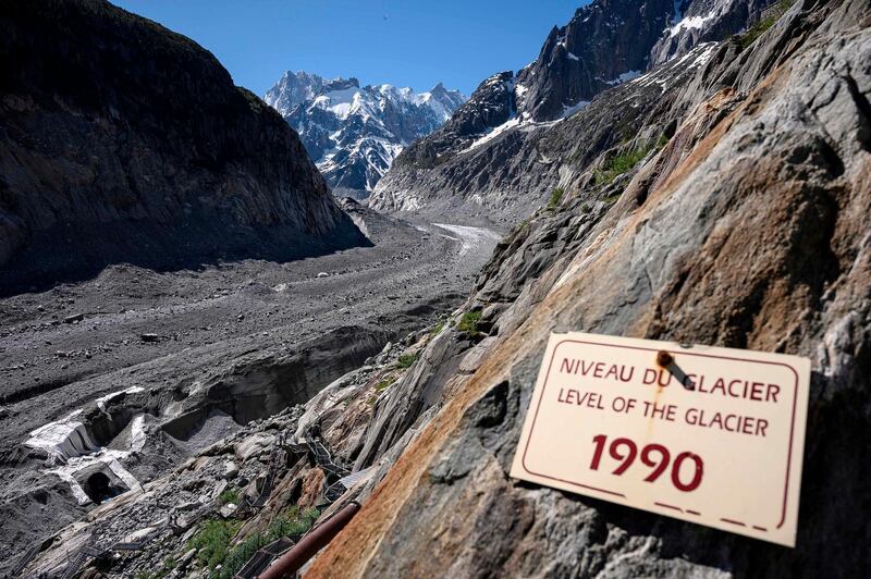 The board indicating the level of the Mer de Glace glacier in 1990 is pictured in Chamonix on June 17, 2019. / AFP / MARCO BERTORELLO
