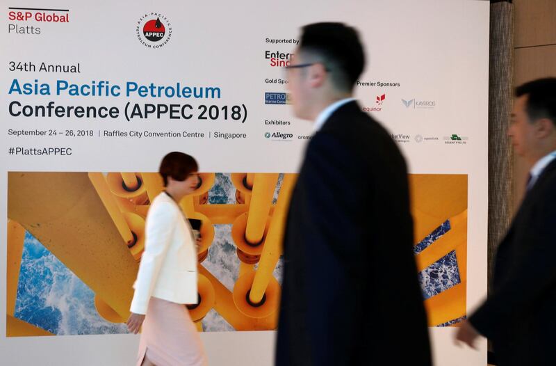 People pass a signage of the 34th Asia Pacific Petroleum Conference (APPEC) in Singapore September 24, 2018. REUTERS/Edgar Su