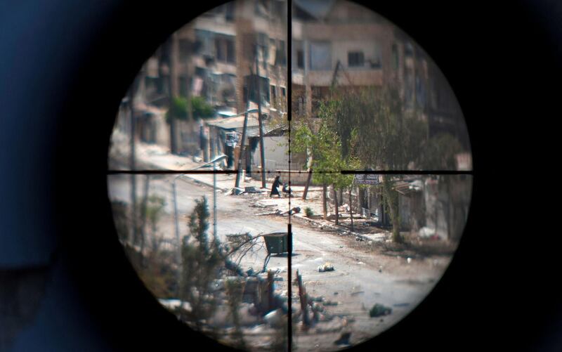 A woman and her baby are seen through the scope of an opposition fighter sniper gun, as she flees the Saif Al Dawla neighbourhood of the Syrian northern city of Aleppo, amid heavy street fighting. AFP