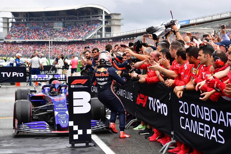 Kvyat runs to celebrate with his Toro Rosso mechanics. AFP