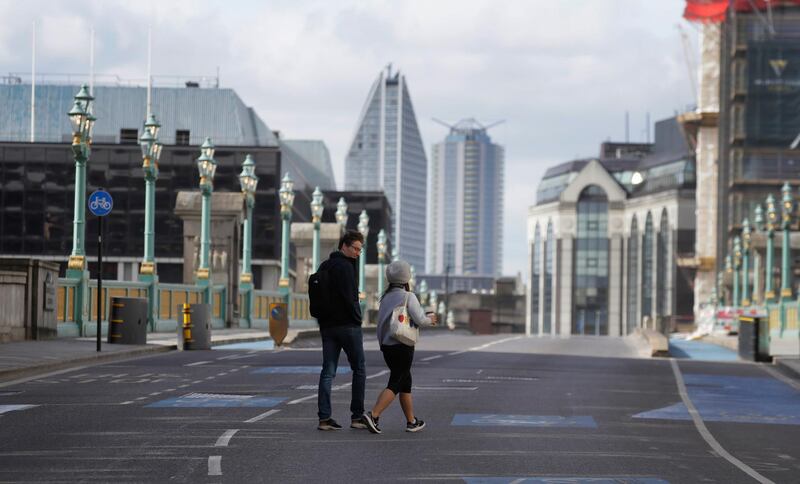 Pedestrians cross the road on Southwark Bridge during the morning rush hour. AP