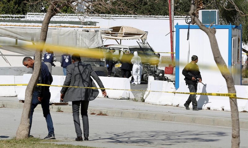 A forensic expert and police officers are seen at the site of a suicide attack near the U.S. embassy in Tunis, Tunisia. REUTERS