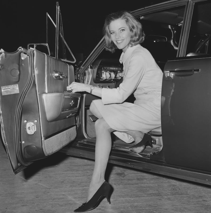 English Actress Honor Blackman smiles while coming out from a car, UK, 26th March 1964. (Photo by Larry Ellis/Daily Express/Hulton Archive/Getty Images)