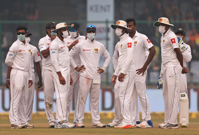 Sri Lanka's players gather wearing anti-pollution masks after the dismissal of India's Ravichandran Ashwin during the second day of their third test cricket match in New Delhi, India. Altaf Qadri / AP Photo